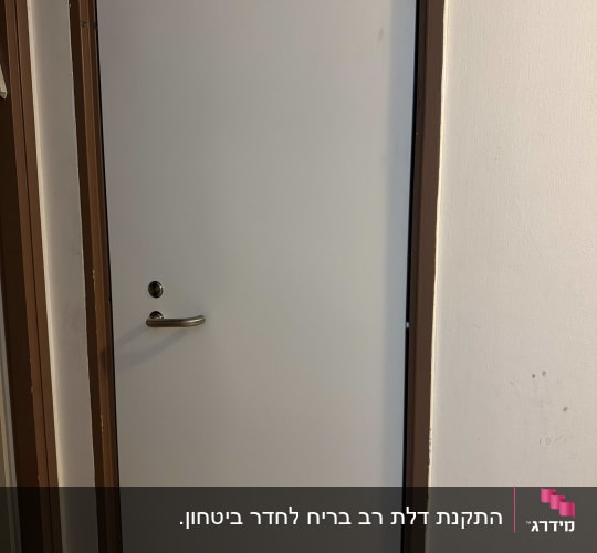 דלת לבנה עם ידית כסופה במסגרת חומה